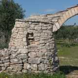 A introdurre la struttura c�� un arco in tufo sostenuto da due pilastrini in pietra calcarea. In uno di essi notiamo un volto con le sembianze di un anziano con il cappello, realizzato a rilievo all�interno di una piccola nicchia